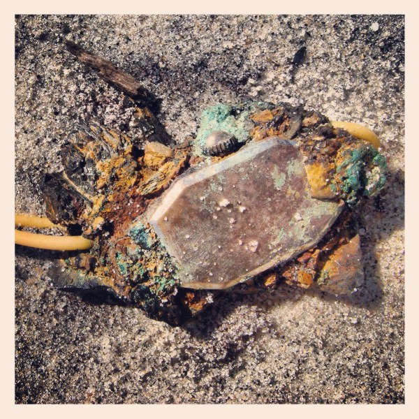Many of the objects at Deadhorse Bay occur in these conglomerate forms, where heat and pressure in the original landfill partly melted and fused glass together with other objects, or, in this case, metal later exposed to salt water corroded objects together. Now, just a hint of the original watch remains. Photograph by Max Liboiron.
