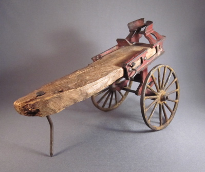 Cast iron horse drawn ladder wagon, c.1900. "A small cast iron fragment is all that remains of an elaborate miniature horse drawn ladder wagon. Someone loved their toy almost “to death” and I am grateful to whoever nailed the remains to a scrap of wood, breathing new life in to their cherished plaything."