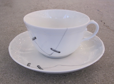 This is actually a faux repaired tea cup. These were created in 2010 by architect and product designer Paola Navone and feature printed cracks “repaired” with trompe l’oeil metal staples. 