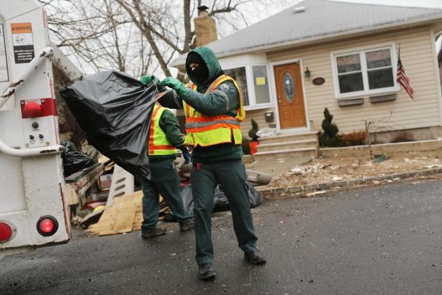 Sanitation workers remove debris from a flood-damaged Staten Island home. Now, some Sanitmen are contesting their post-hurricane cleanup pay. Photo by Spencer Platt. February 26, 2013.