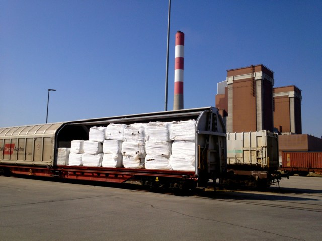 Rail cars with prepared waste bales, potentially from Italy or Slovenia. The two towers and chimney of the coal-fired power plant are visible behind the yard. Author’s photo.