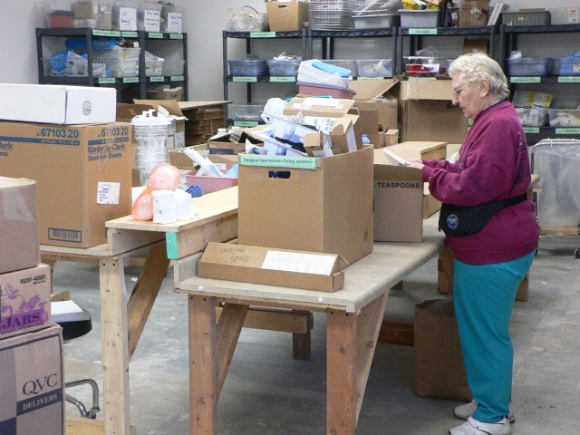 Figure 1. An IHM volunteer whom I call Harriet, and with whom I regularly worked, sorting medical donations; at the time of my fieldwork in 2005-2006, Harriet, a retired missionary nurse, had spent 16 years volunteering at the agency. She passed away in 2010.