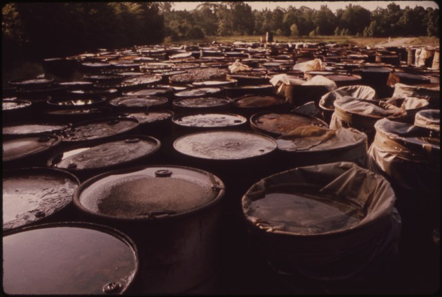 ABOUT_3,000_DRUMS_CONTAINING_HAZARDOUS_INDUSTRIAL_WASTES_HAVE_BEEN_STORED_FOR_SIX_MONTHS_IN_THIS_SWAMPY_FIELD_NEAR..._-_NARA_-_552885