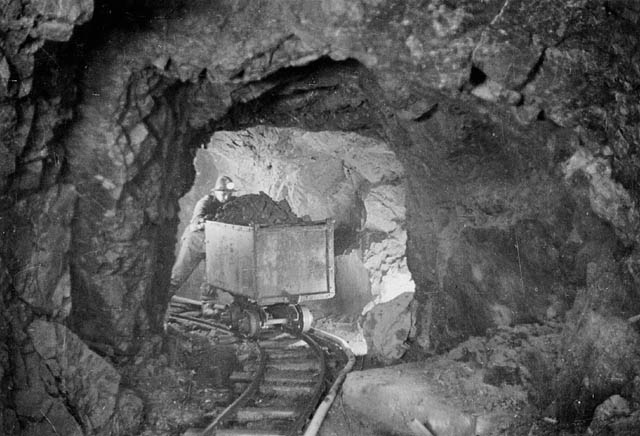 A_miner_hauling_a_car_of_silver_radium_ore,_340_feet_below_the_surface,_Eldorado_Mine_of_Great_Bear_Lake