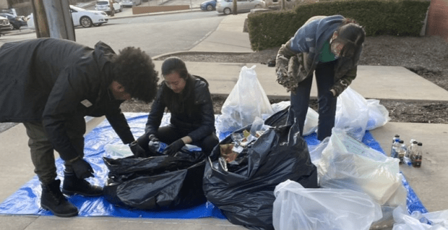 Young adults searching through clear and opaque garbage bags